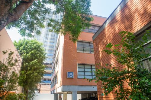 Edifícios de tijolos e concreto com janelas, cercados por árvores frondosas. O Instituto Mauá de Tecnologia é visível.