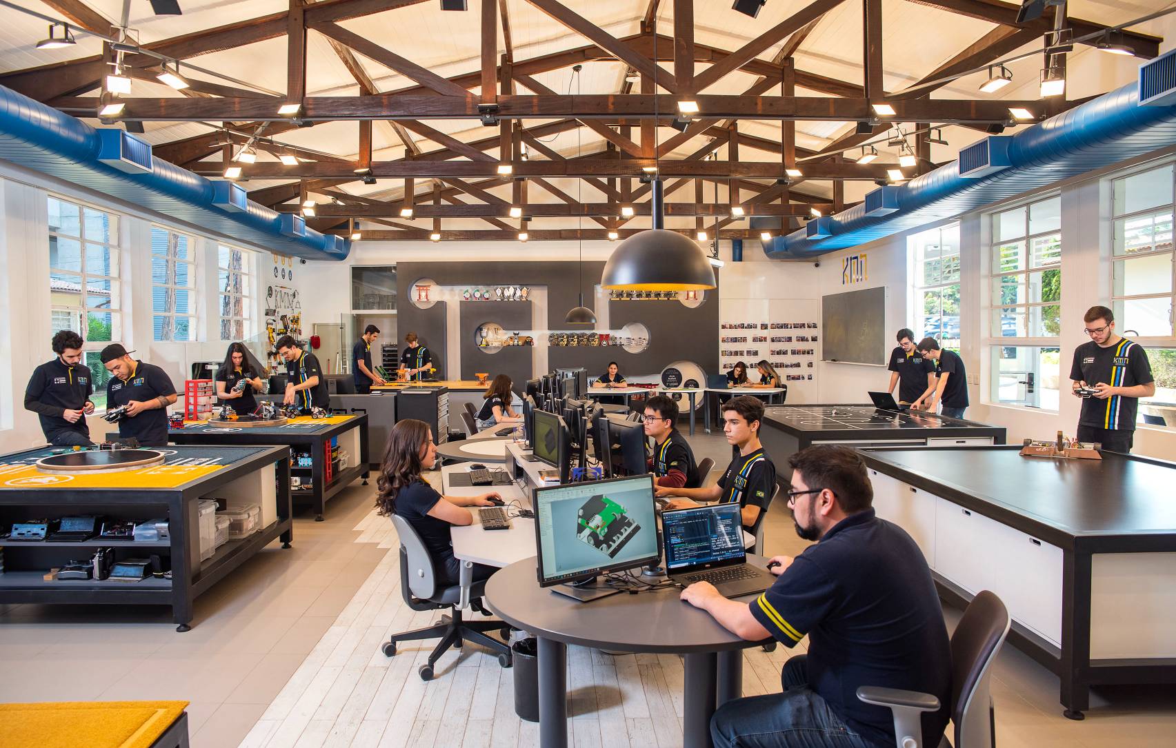 Alunos do Instituto Mauá de Tecnologia estudam em sala de aula com computadores e testam robôs