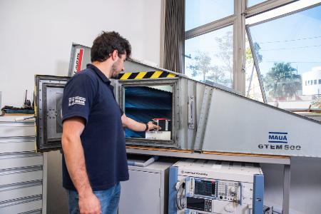 Estudante do Instituto Mauá de Tecnologia opera máquina de medição de precisão em laboratório.